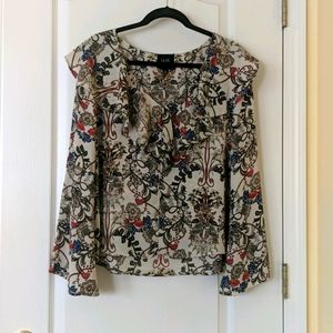 Patterned v-neck blouse with ruffle detail.